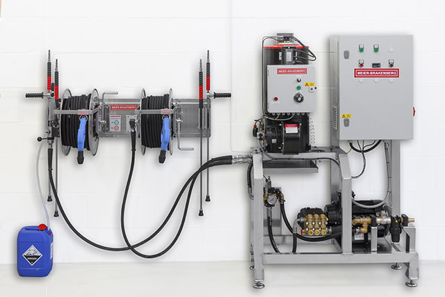 Frequency controlled high-pressure aggregate for up to 3,000 l/h or 4,200  l/h and integrated hot-water unit MBHot, infinitely variable up to 90° C. The illustrated operating panel includes hose reels for two simultaneously working users. Therefore it is possible to place the pump unit inside the equipment room and the hose panel at the washing area.