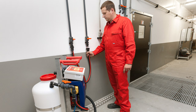 Shown here the mobile medication dosing system located in front of the pen requiring supply of medication. Connection of flow pipe and return flow - and the MBMobil is ready to dose.